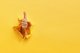 Image of a man's arm punched through a yellow wall, giving a thumbs up [Image by creator WayhomeStudio from AdobeStock]